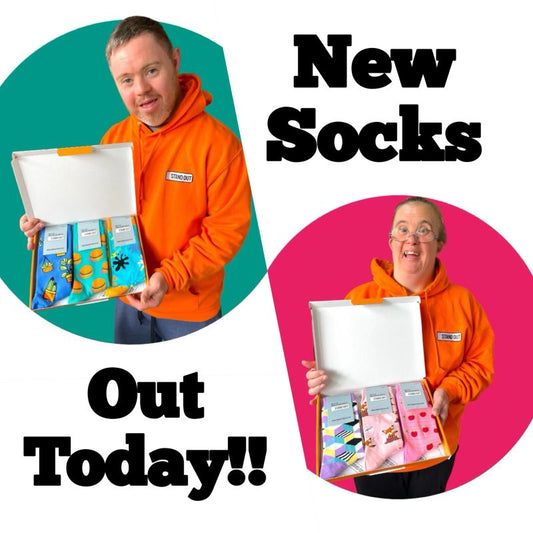 A Man and Woman holding boxes of Stand out socks 