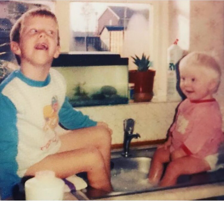 graph of 2 children sat on the kitchen worktop with their feet in a sink full of soapy bubbles