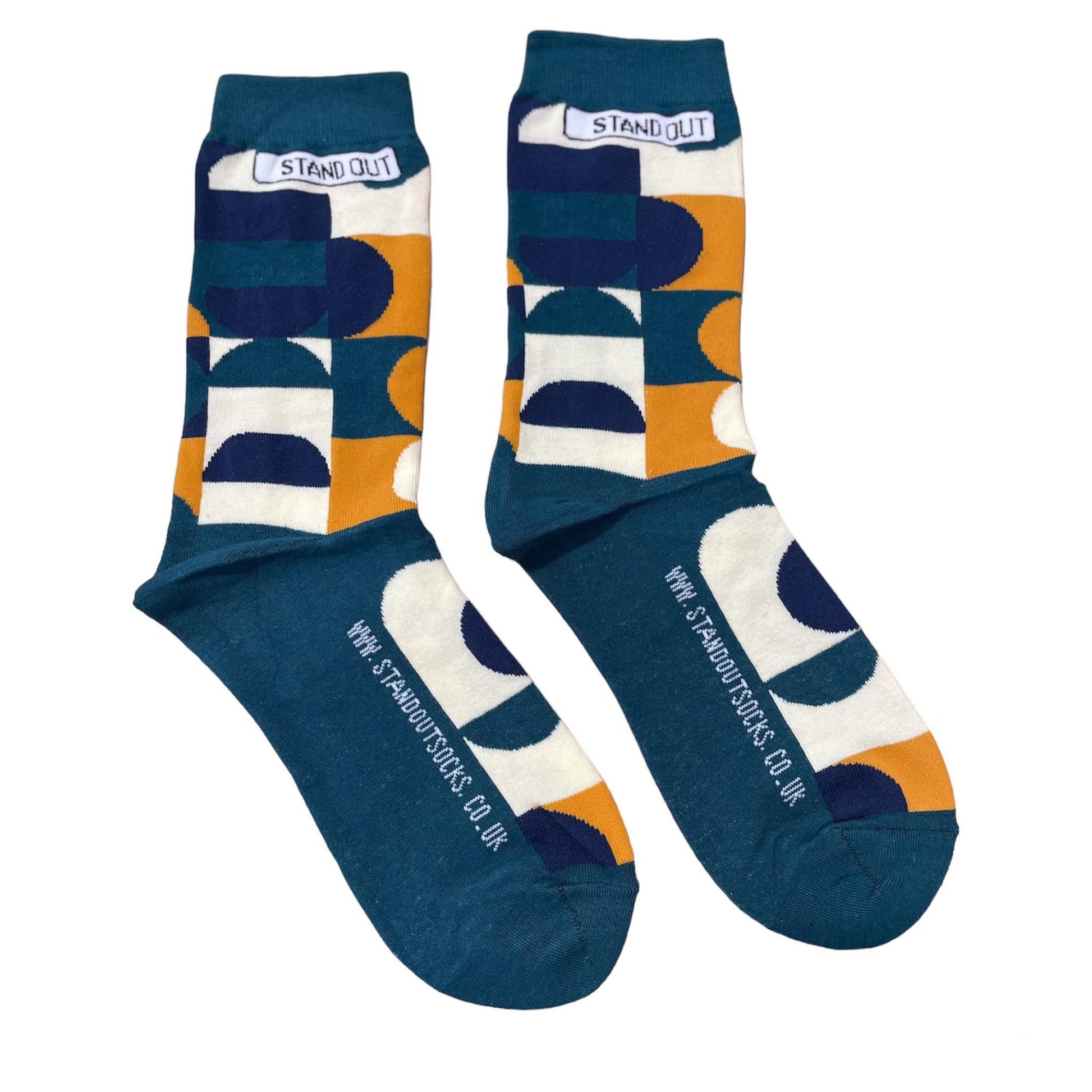 Green Socks with Orange, cream and navy geometric pattern by Stand Out Socks. The Stand Out logo on the top with the Stand Out website on the sole.