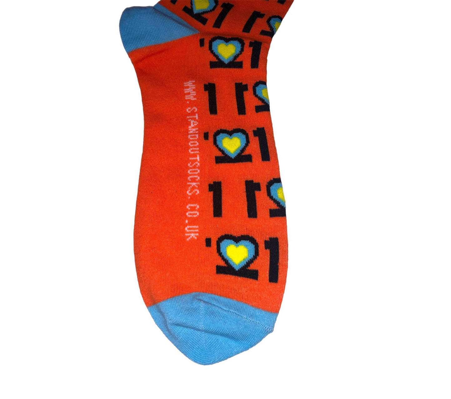 Man with Glasses on and orange jumper, Smiling and holding a pair of colourful Down Syndrome Awareness Socks