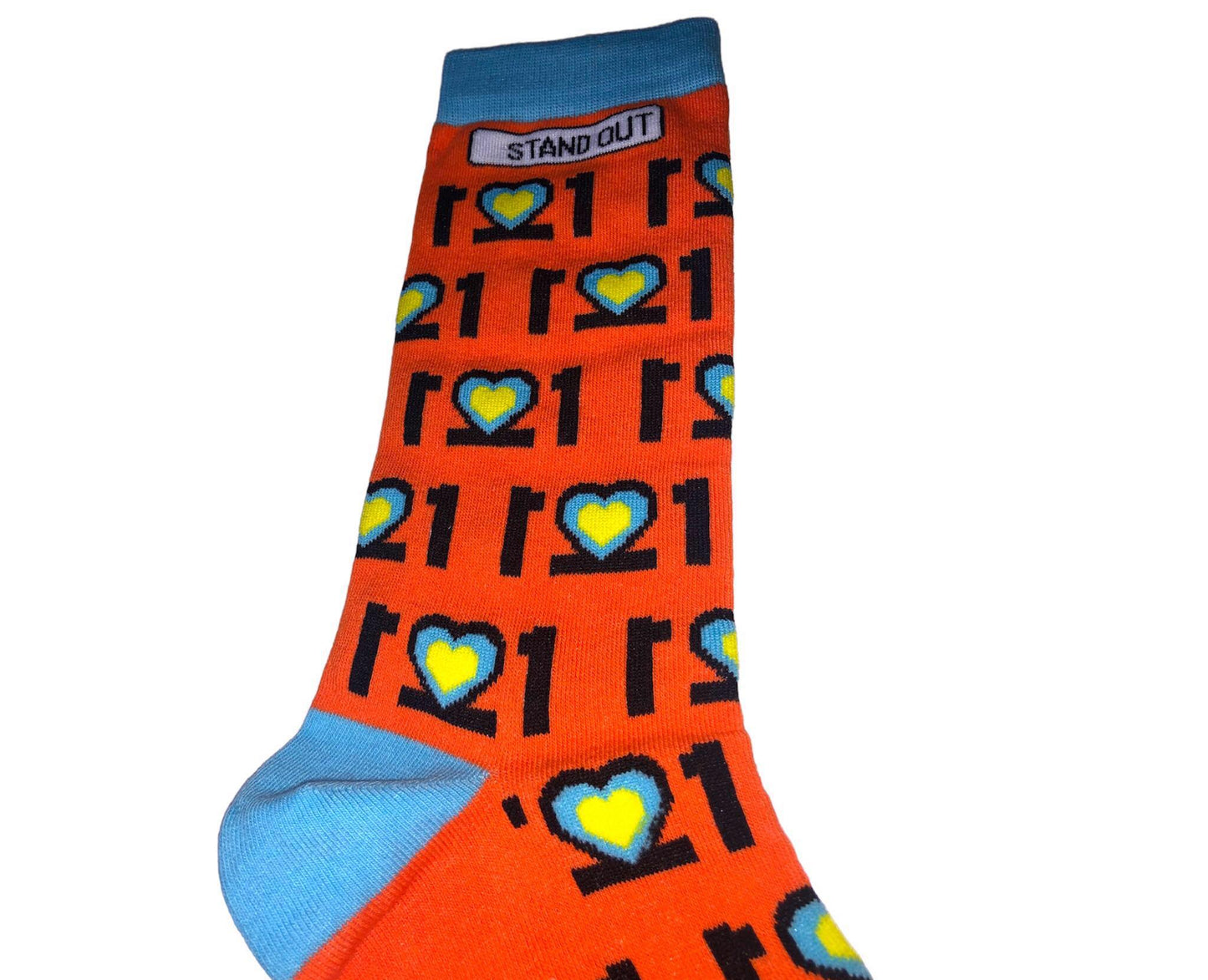 Man with Glasses on and orange jumper, Smiling and holding a pair of colourful Down Syndrome Awareness Socks