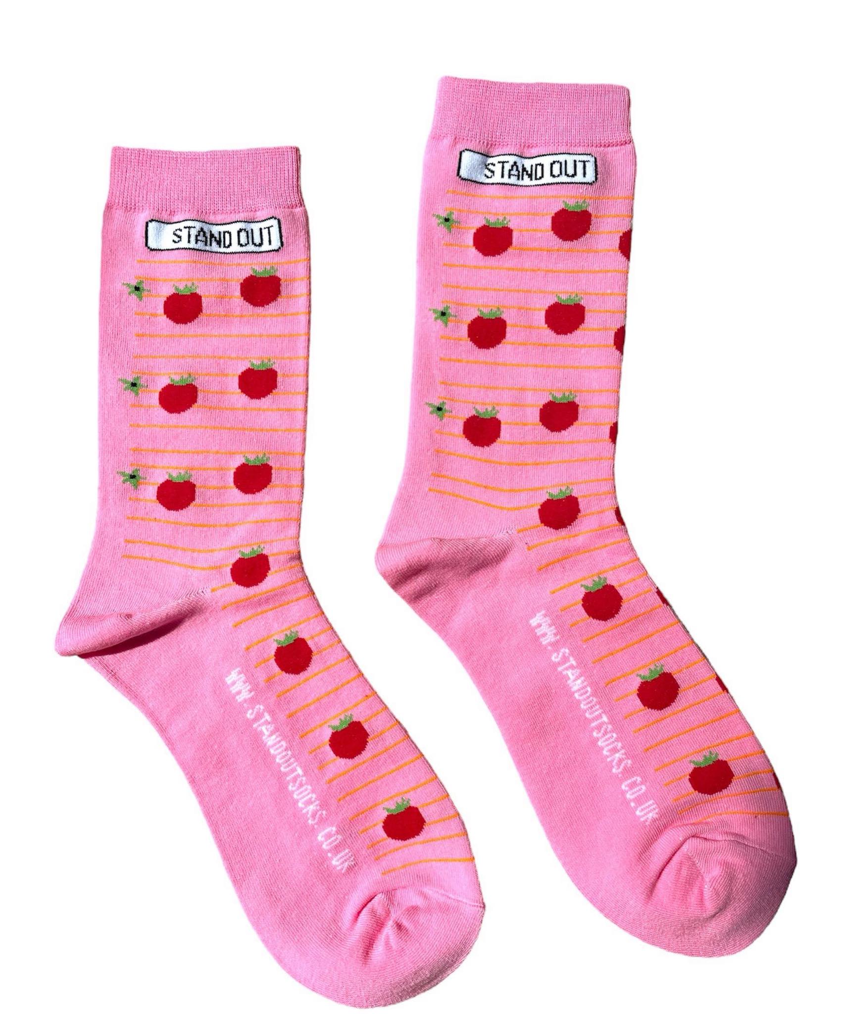 A pair of stand out socks pink socks with tomato's on music lines design and the website www.standoutsocks.co.uk on the foot and the stand out logo on the cuff