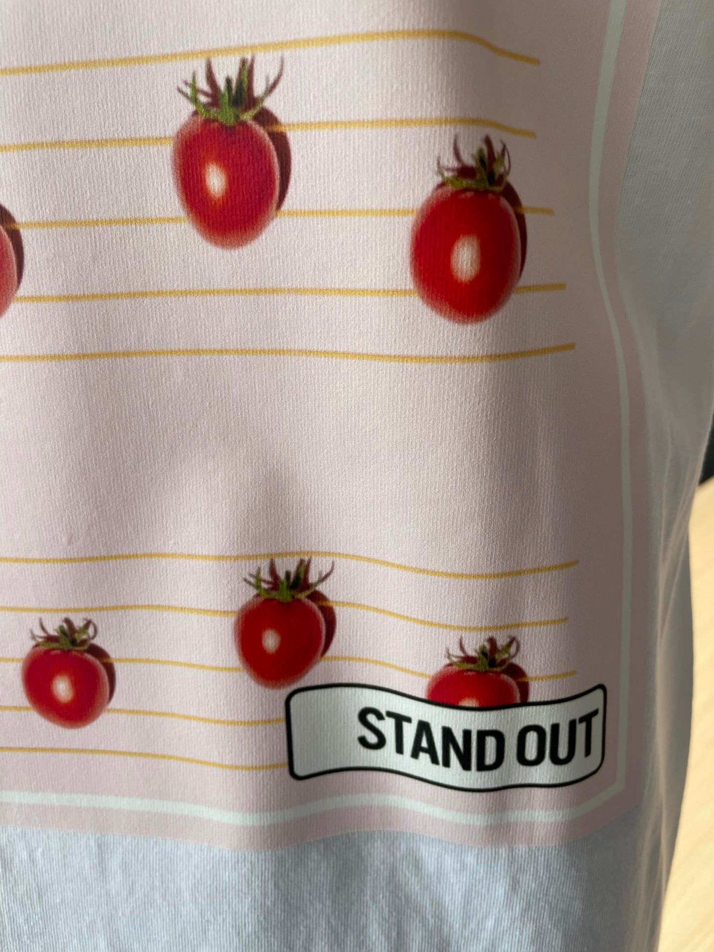 close up of Stand Out Socks White T-shirt with tomato's patten print and the Stand Out Logo